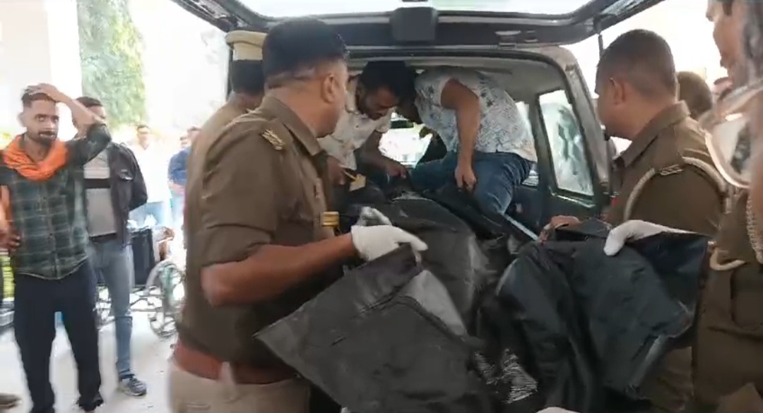 पुलिसकर्मियों द्वारा लाश को गाड़ी पर रखने की फोटो। पुलिसकर्मियों द्वारा लाश को गाड़ी पर रखने की फोटो।