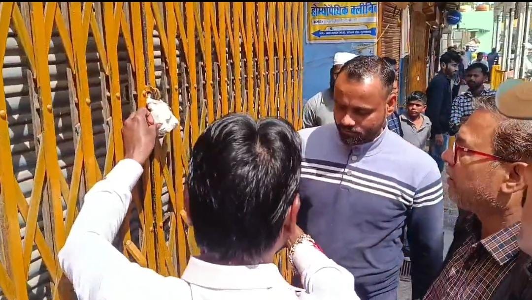 बुध बाजार में दुकान को सील करते नगर निगम के अधिकारी व कर्मचारी। बुध बाजार में दुकान को सील करते नगर निगम के अधिकारी व कर्मचारी।