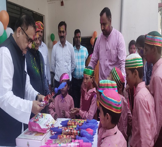 दिव्यांग बच्चों को पिचकारी वितरित करते हुए दिव्यांगजन विभाग के अधिकारी व बच्चों का छाया चित्र