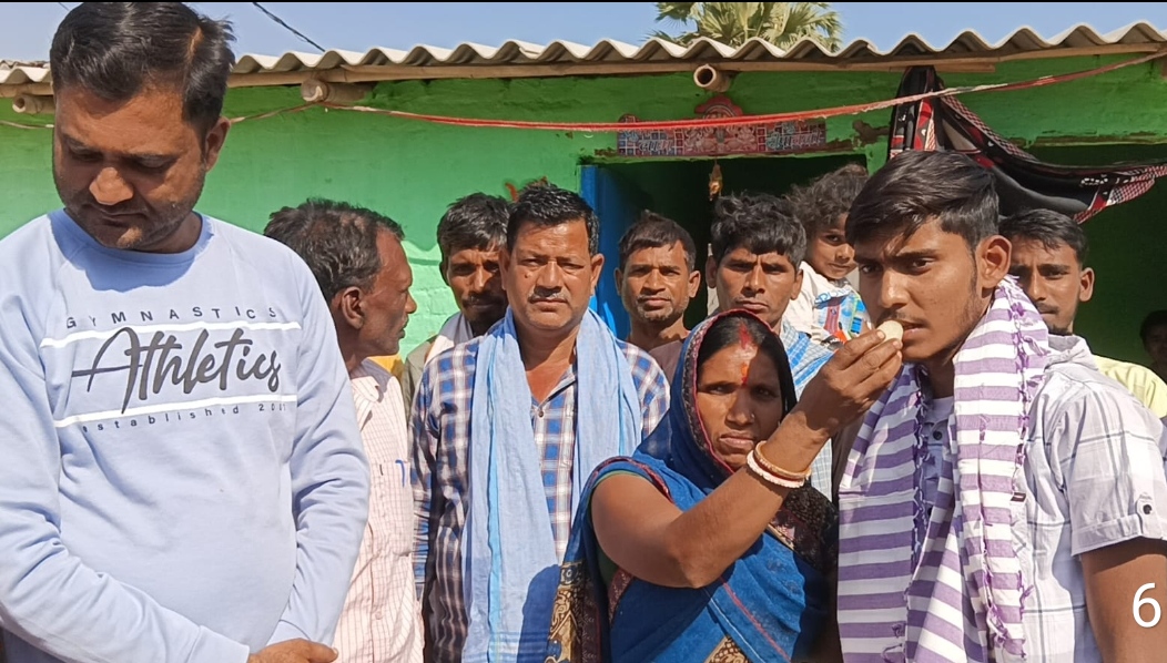 आदर्श को मिठाई खिलाते परिजन आदर्श को मिठाई खिलाते परिजन
