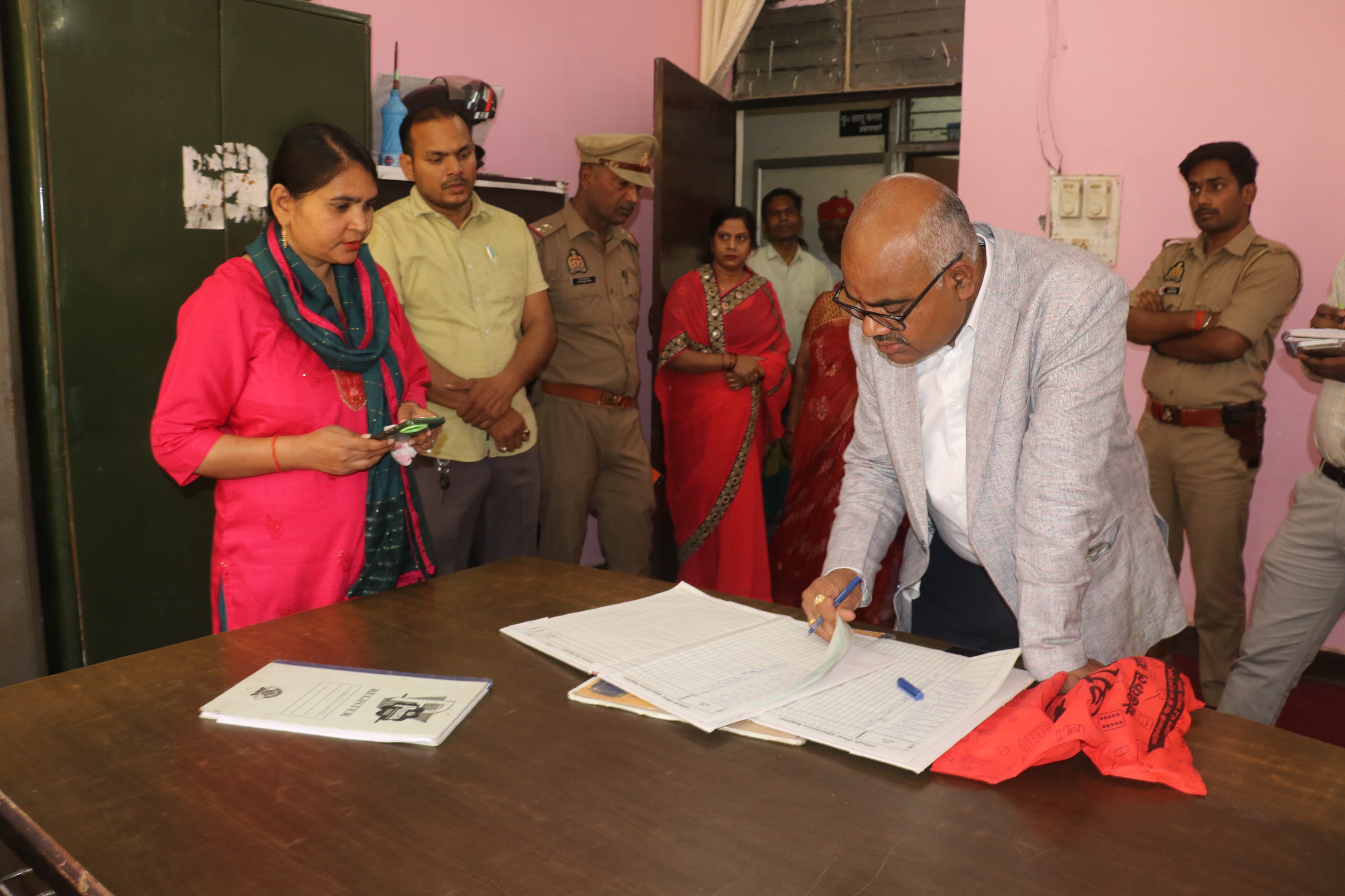 जिलाधिकारी विद्यालय रजिस्टर की जांच करते हुए