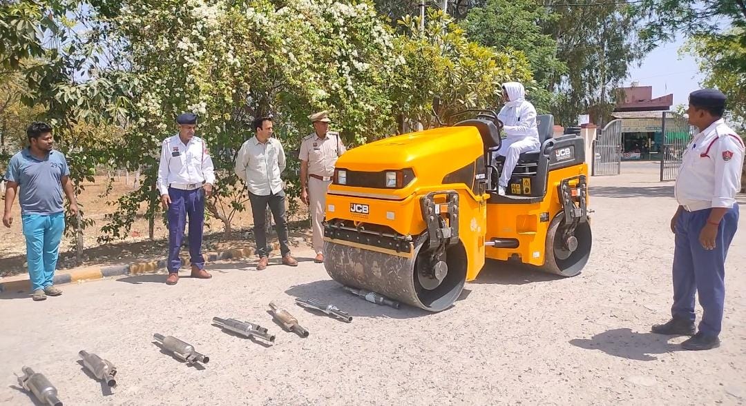 साइलेंसरों पर रोड रोलर चलवाते हुए ट्रैफिक पुलिस अधिकारी। साइलेंसरों पर रोड रोलर चलवाते हुए ट्रैफिक पुलिस अधिकारी।