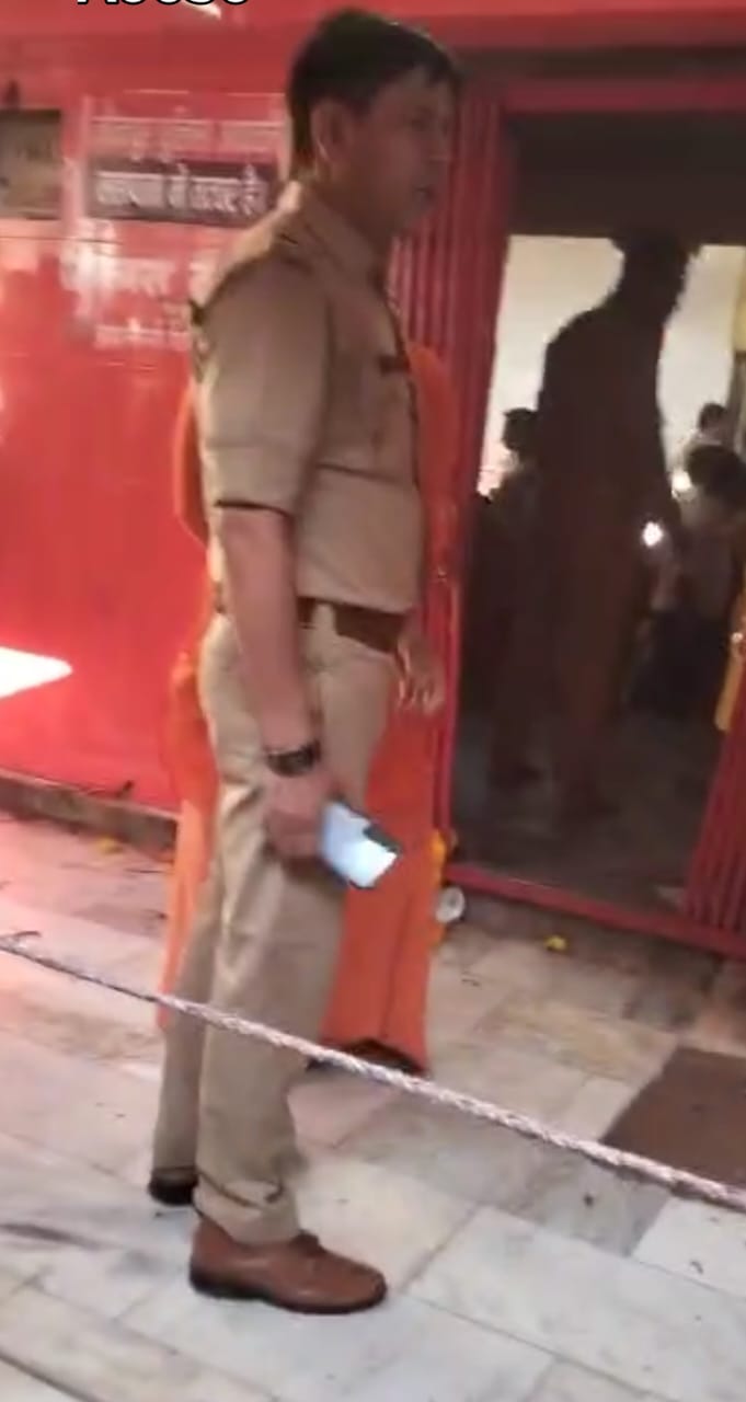 मंदिर परिसर में जूता पहन कर खड़े चौकी इंचार्ज मंदिर परिसर में जूता पहन कर खड़े चौकी इंचार्ज