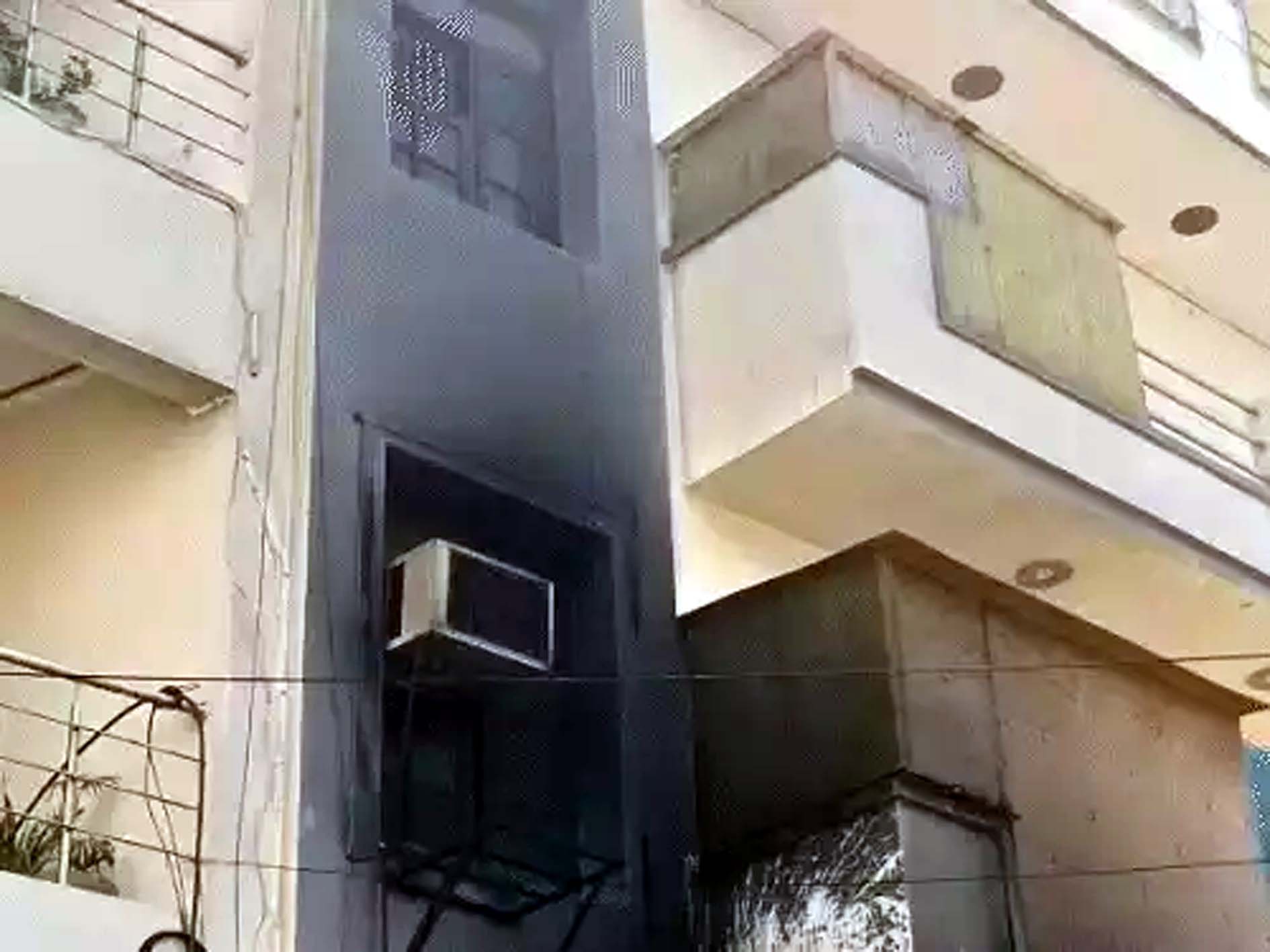 आग की वजह से काली हुई पास की बिल्डिंग। आग की वजह से काली हुई पास की बिल्डिंग।