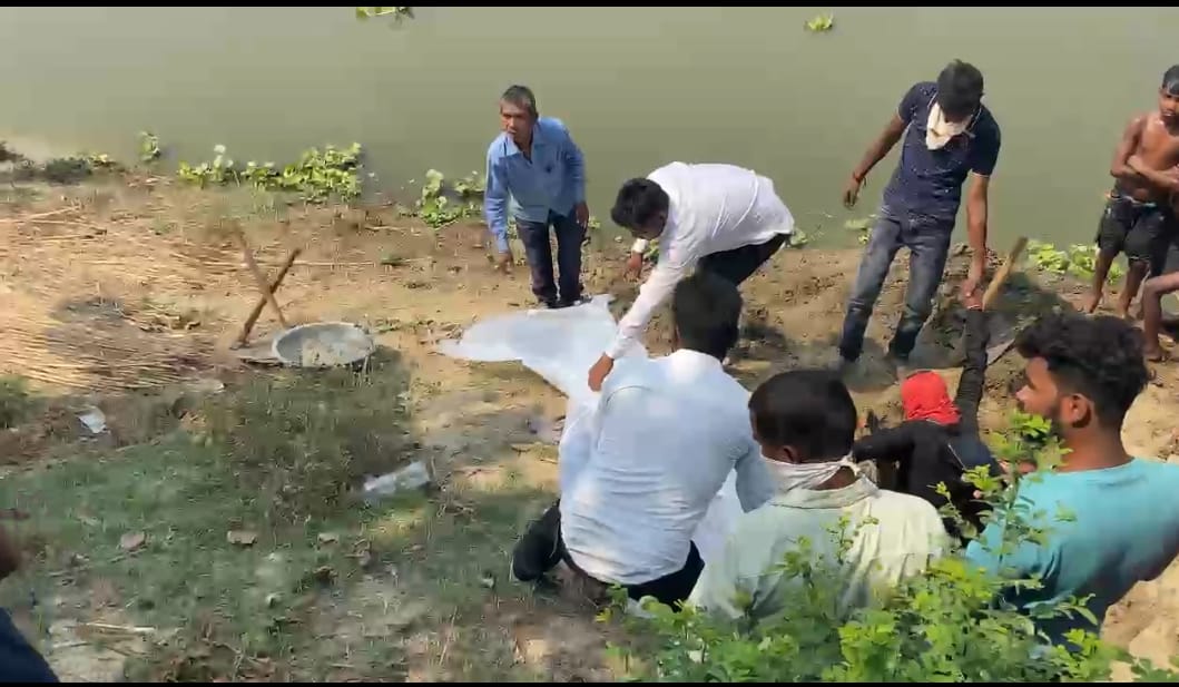 नदी किनारे से बच्चे का शव निकलते पुलिस के जवान नदी किनारे से बच्चे का शव निकलते पुलिस के जवान