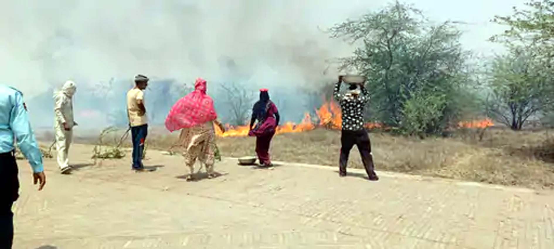 तसलों में मिट्टी भरकर आग बुझाने का प्रयास करते ग्रामीण। तसलों में मिट्टी भरकर आग बुझाने का प्रयास करते ग्रामीण।