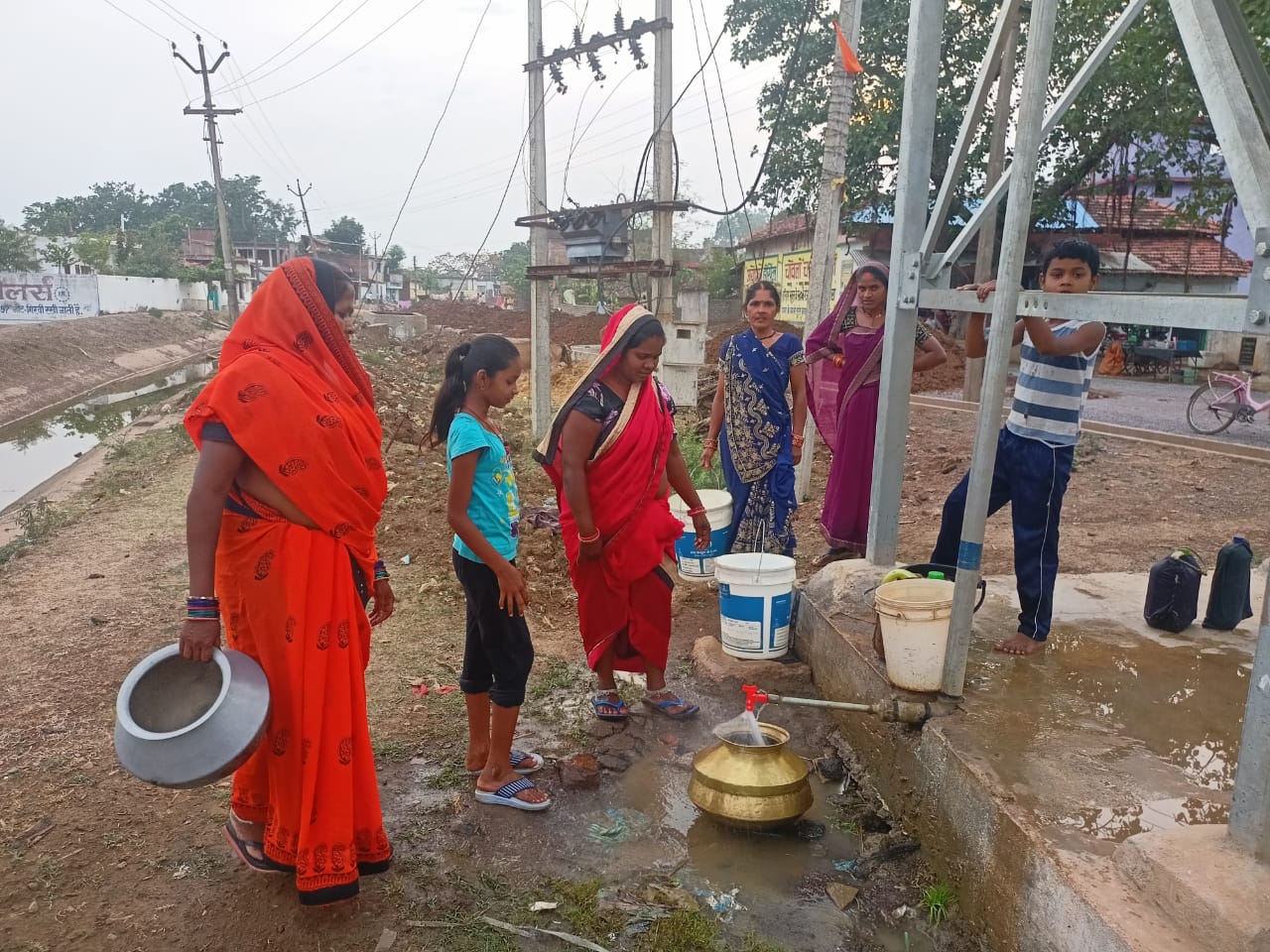 सोलर पंप की मरम्मत के बाद पानी लेते हुए ग्रामीण।