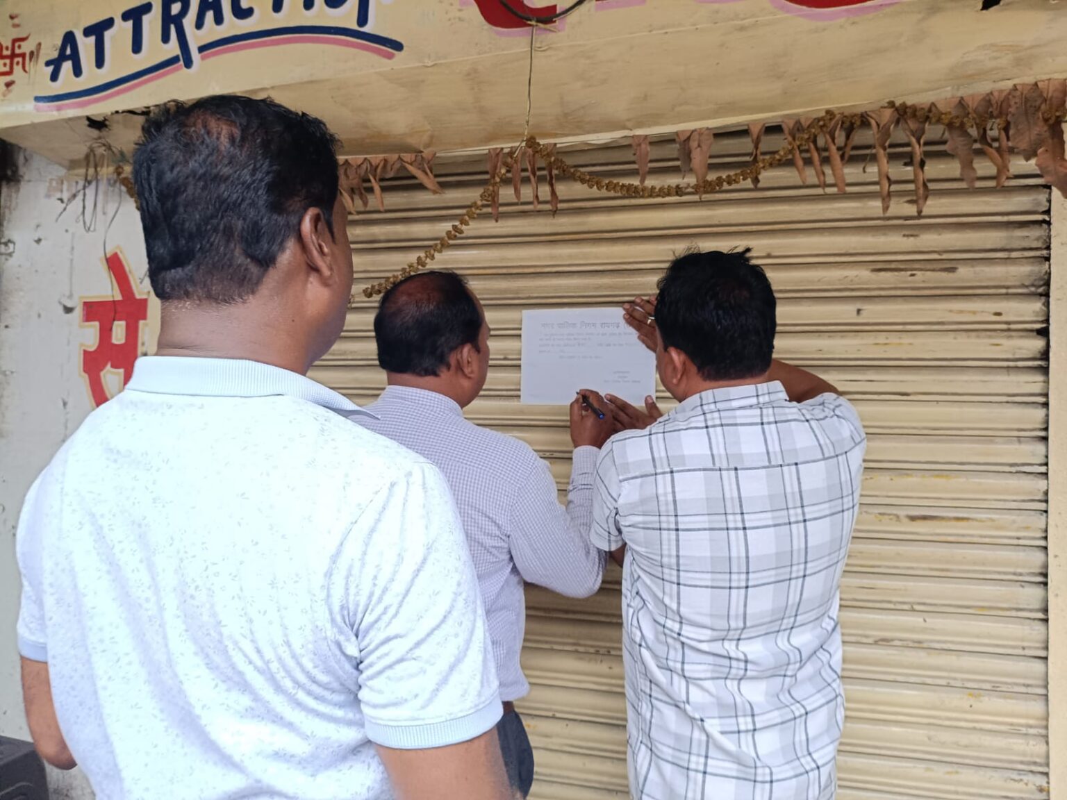 दुकान सील करते हुए नगर निगम के कर्मचारी