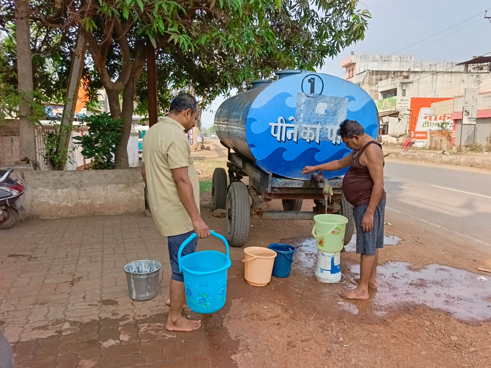 नगर निगम के पानी टैंकर से पानी लेते हुए वार्डवासी।