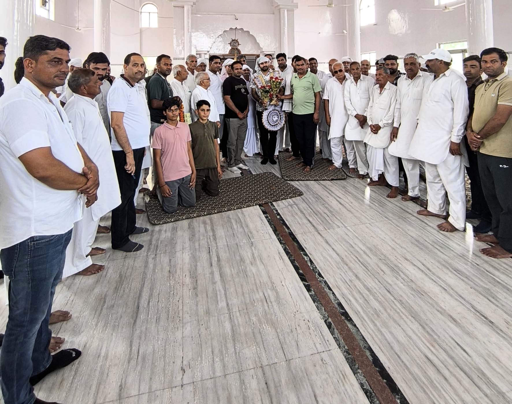 यूपीएसससी में चयनित डॉ. विक्रम का स्वागत करते ग्रामीण।