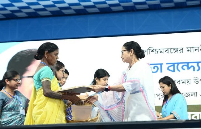 लाभार्थियों को घर बनाने के लिए सहायता देती हुईं मुख्यमंत्री