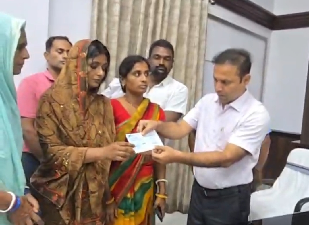 चेक देते जिलाधिकारी