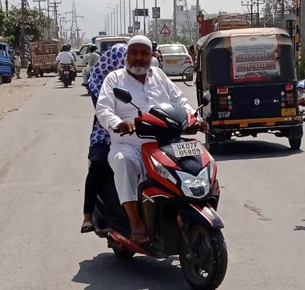 बगैर हेलमेड के चलते एक बुजुर्ग।
