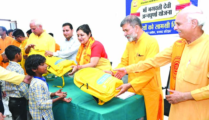 स्कूल बैग वितरित करते हुए स्कूल बैग वितरित करते हुए