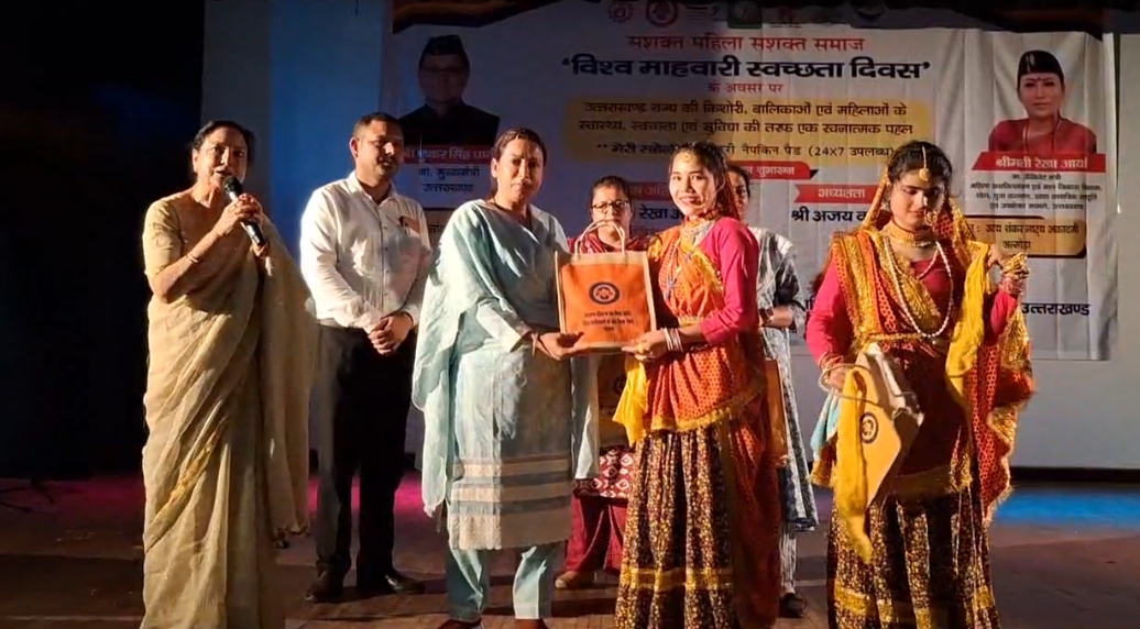 मंत्री रेखा आर्य महिलाओं और किशोरियों को स्वच्छता किट वितरित करती। मंत्री रेखा आर्य महिलाओं और किशोरियों को स्वच्छता किट वितरित करती।