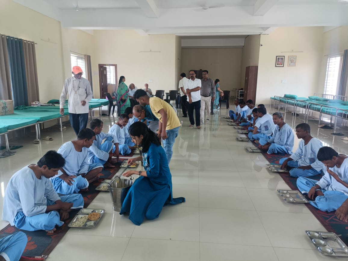 निराश्रितों को भोजन कराते ट्रस्ट के सदस्यों की तस्वीर निराश्रितों को भोजन कराते ट्रस्ट के सदस्यों की तस्वीर