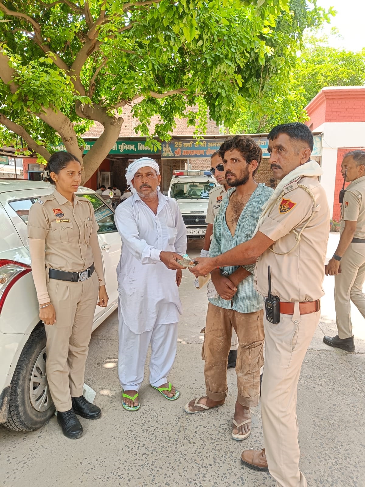 किसान को पैसे वापस लौटाते पुलिसकर्मी। किसान को पैसे वापस लौटाते पुलिसकर्मी।