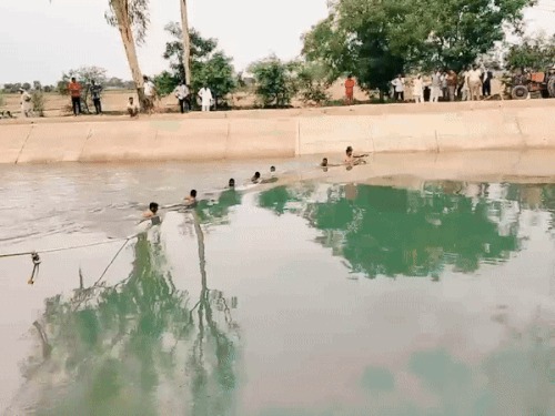नहर में डूबे युवक को चेन बना कर ढूंढते हुए। नहर में डूबे युवक को चेन बना कर ढूंढते हुए।