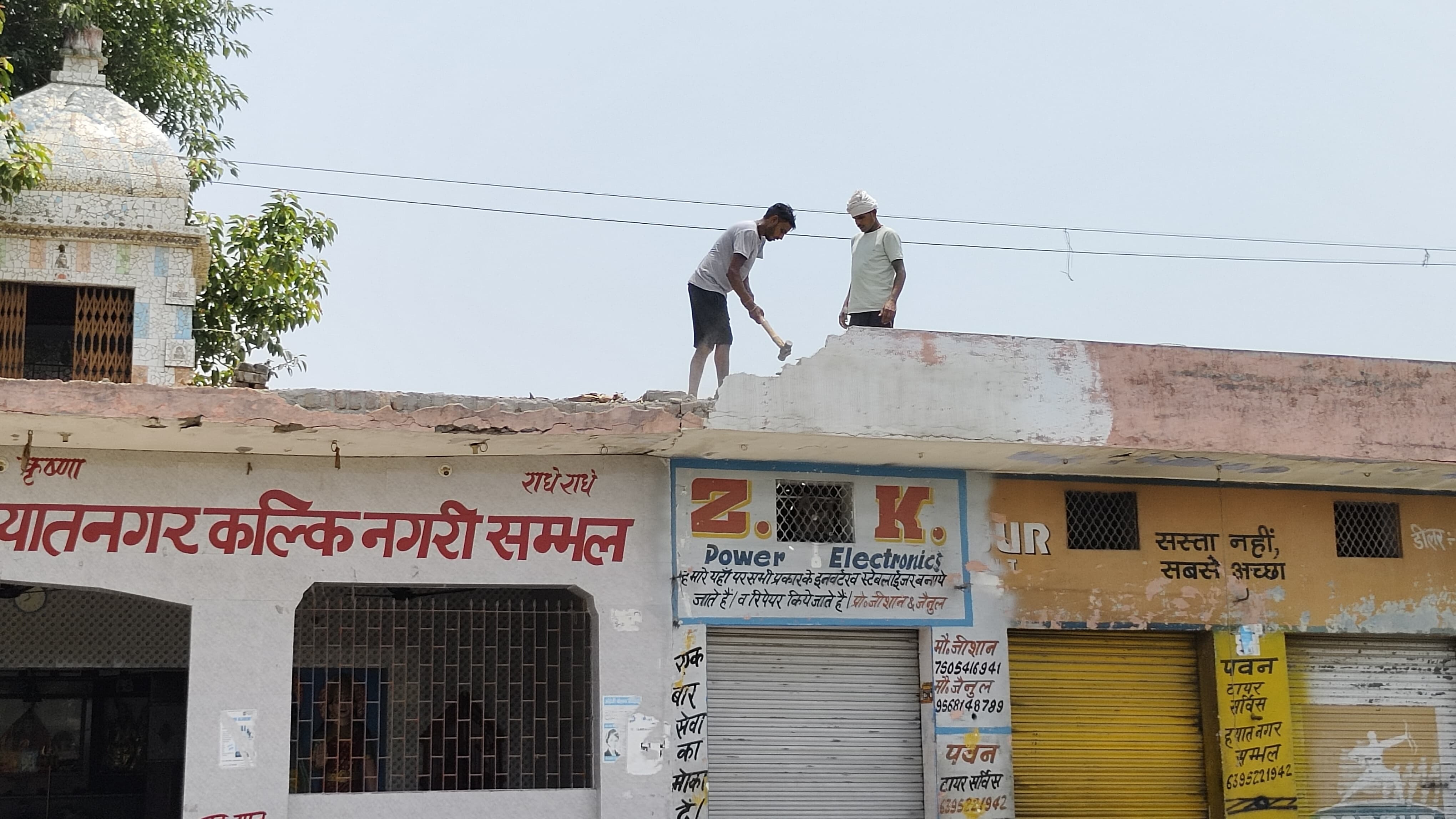 मंदिर के छत का हिस्सा तोड़ रहे मजदूर मंदिर के छत का हिस्सा तोड़ रहे मजदूर