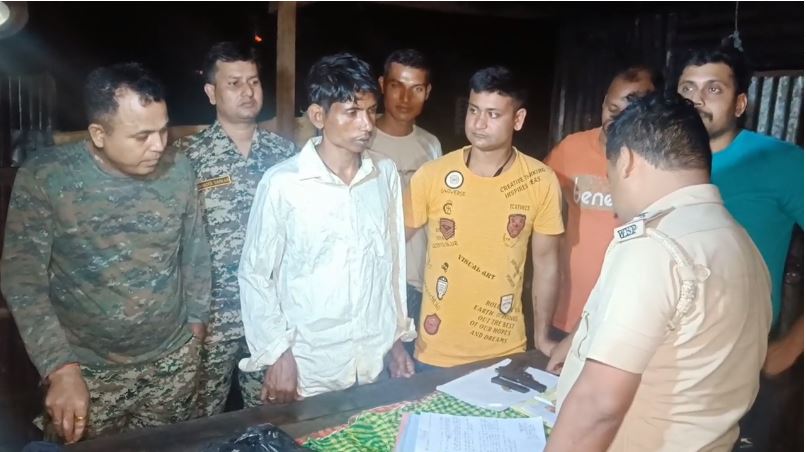 आग्नेयास्त्र के साथ गिरफ्तार अपराधी से पूछताछ करती पुलिसकर्मी आग्नेयास्त्र के साथ गिरफ्तार अपराधी से पूछताछ करती पुलिसकर्मी