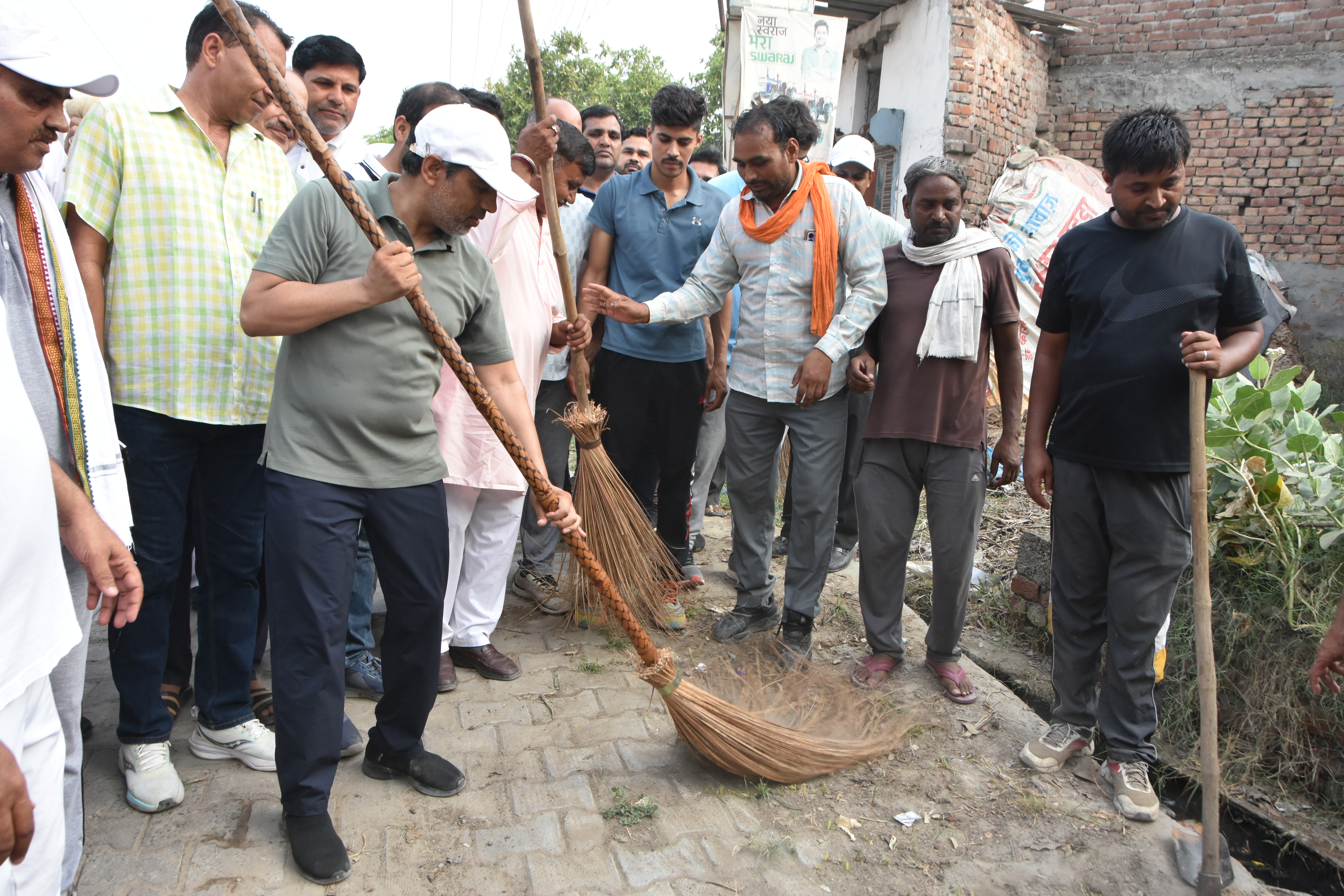 गांव उग्रा खेड़ी में सफाई अभियान के तहत झाड़ू लगाते शिक्षा मंत्री महिपाल डंडा