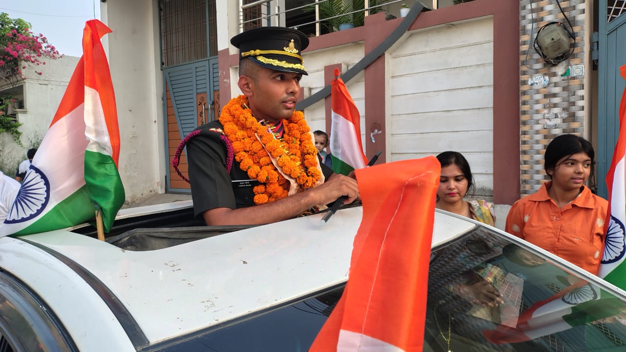 भारतीय सेना की वर्दी में गाड़ी के ऊपर खड़े होकर हाथ में तिरंगा लहराते हुए लेफ्टिनेंट तरुण सैनी। स्वागत जुलूस के दौरान जयघोषों से गूंजा वातावरण।