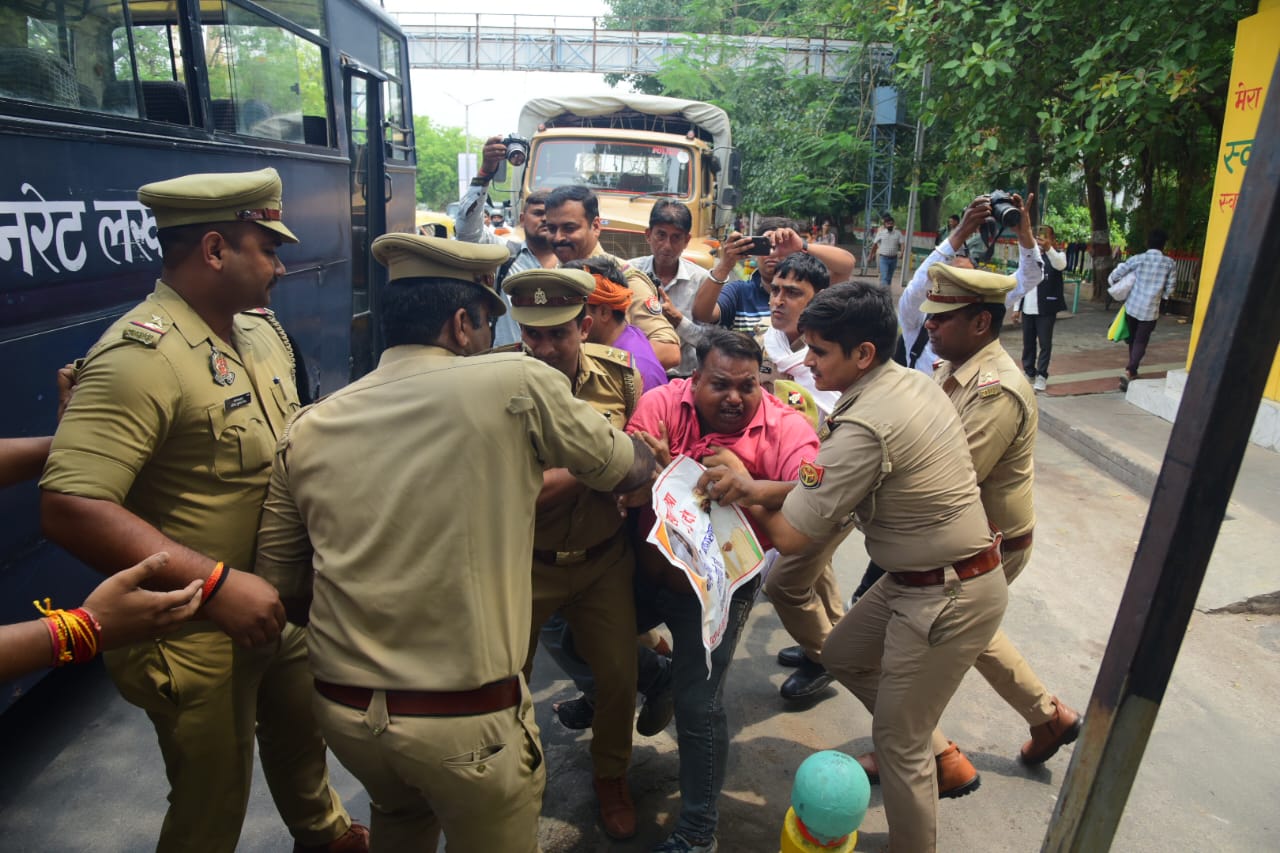 प्रदर्शन करने जा रहे आआपा कार्यकर्ता को हिरासत में लेती पुलिस।