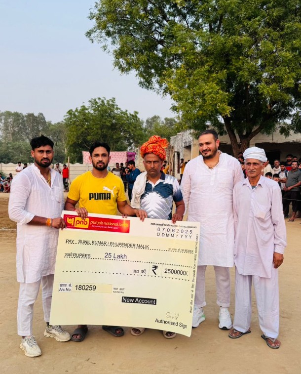 सुनील कुमार अपने कोच को 25 लाख का चेक देते हुए सुनील कुमार अपने कोच को 25 लाख का चेक देते हुए