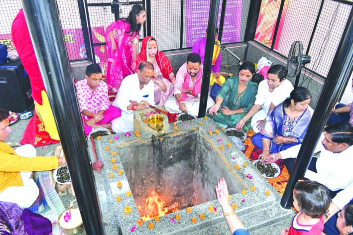 यज्ञ में आहूति देते हुए