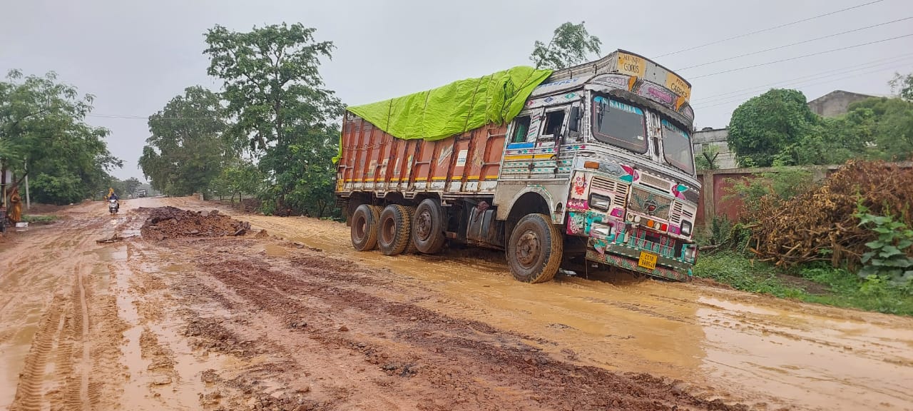 सड़क किनारे धंस गया है ट्रक। सड़क किनारे धंस गया है ट्रक।
