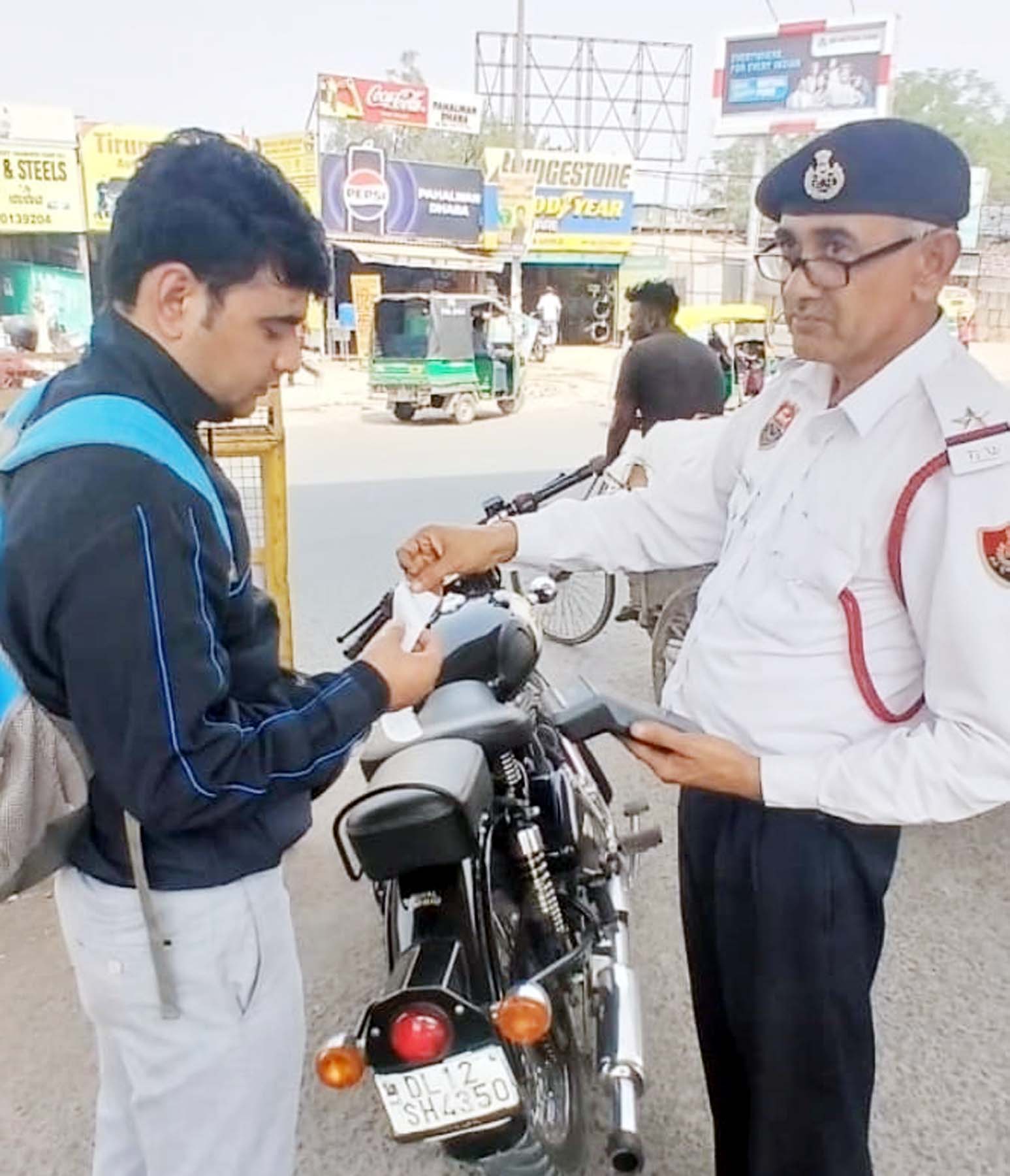 पटाखा बुलेट वाले युवक का चालान काटते यातायात पुलिसकर्मी। पटाखा बुलेट वाले युवक का चालान काटते यातायात पुलिसकर्मी।