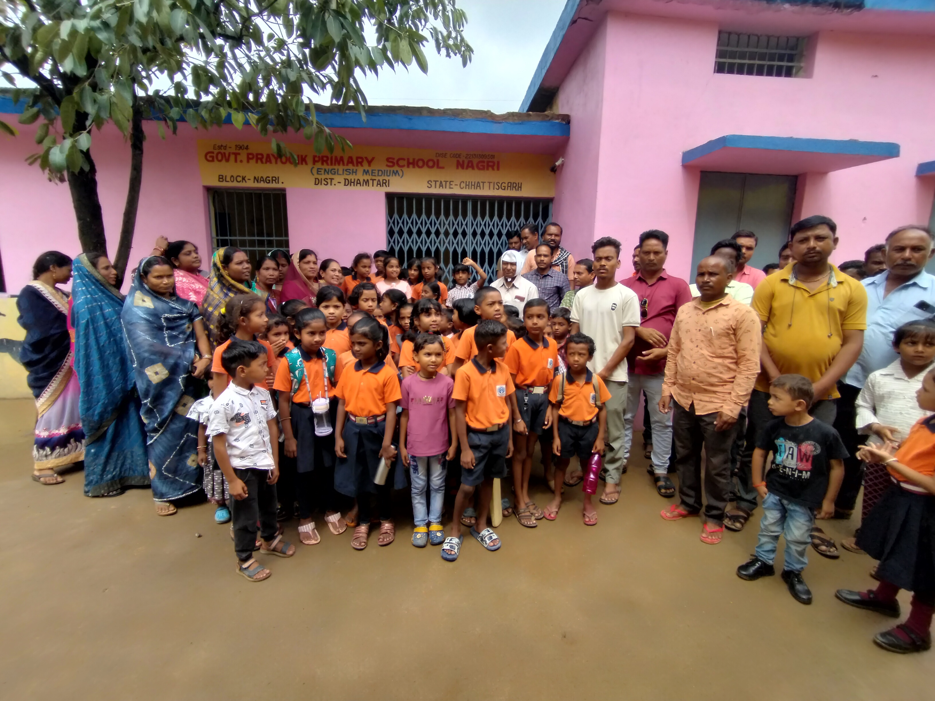 स्कूल के सामने समूह में खड़े हुए पालक व बच्चे। स्कूल के सामने समूह में खड़े हुए पालक व बच्चे।
