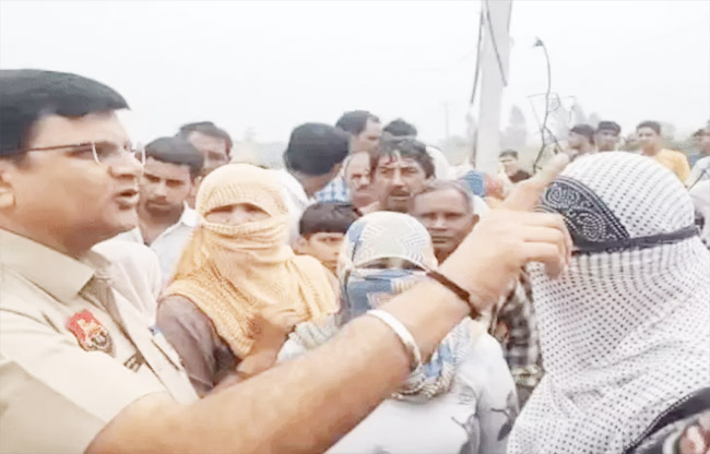 खानपुर  में महिलाओं साथ बात करते हुए पुलिस अधिकारी