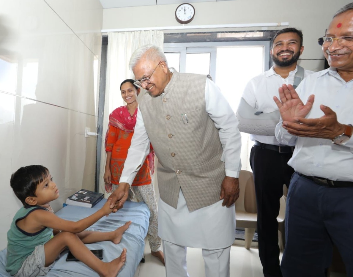 राज्यपाल पटेल बीमार बच्चे से बात करते हुए