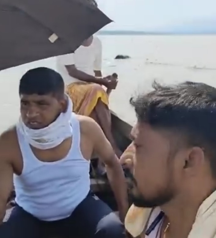 नाव से शव को खींचते लोग नाव से शव को खींचते लोग