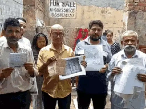 नेहरू कालोनी के लोग नोटिसों को दिखाते हुए नेहरू कालोनी के लोग नोटिसों को दिखाते हुए
