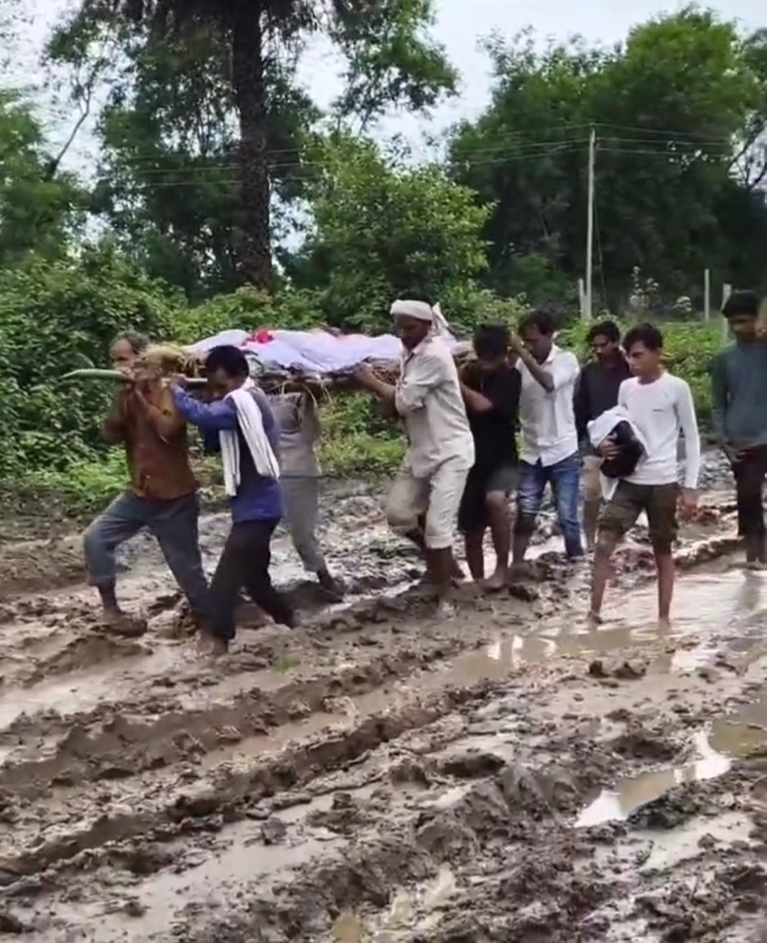 मानवीयता शर्मसार: कीचड़ में गिरते-पड़ते व-मुश्किल शवयात्रा में शामिल हुए लोग मानवीयता शर्मसार: कीचड़ में गिरते-पड़ते व-मुश्किल शवयात्रा में शामिल हुए लोग