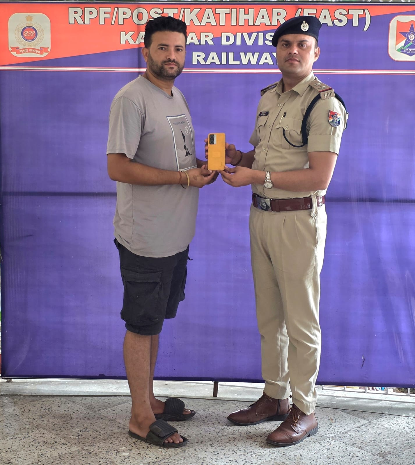 यात्री को मोबाइल देते हुए आरपीएफ यात्री को मोबाइल देते हुए आरपीएफ