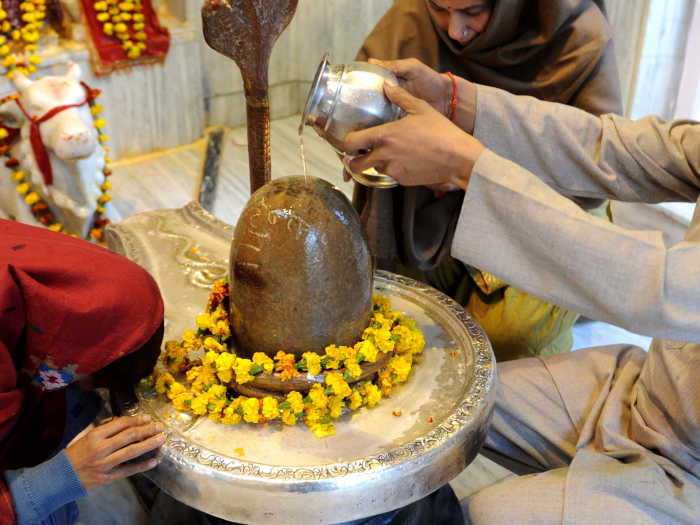 शिवलिंग की पूजा करते हुए भक्त। शिवलिंग की पूजा करते हुए भक्त।
