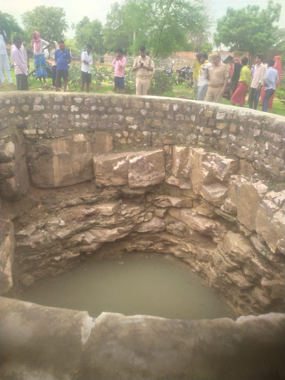 बैधा गांव में कुएं में गिरी युवती को देखते ग्रामीण।