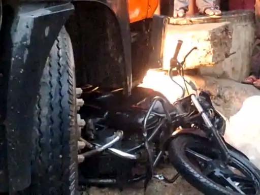 हादसे में ट्रक के नीचे फंसी हुई बाइक। हादसे में ट्रक के नीचे फंसी हुई बाइक।