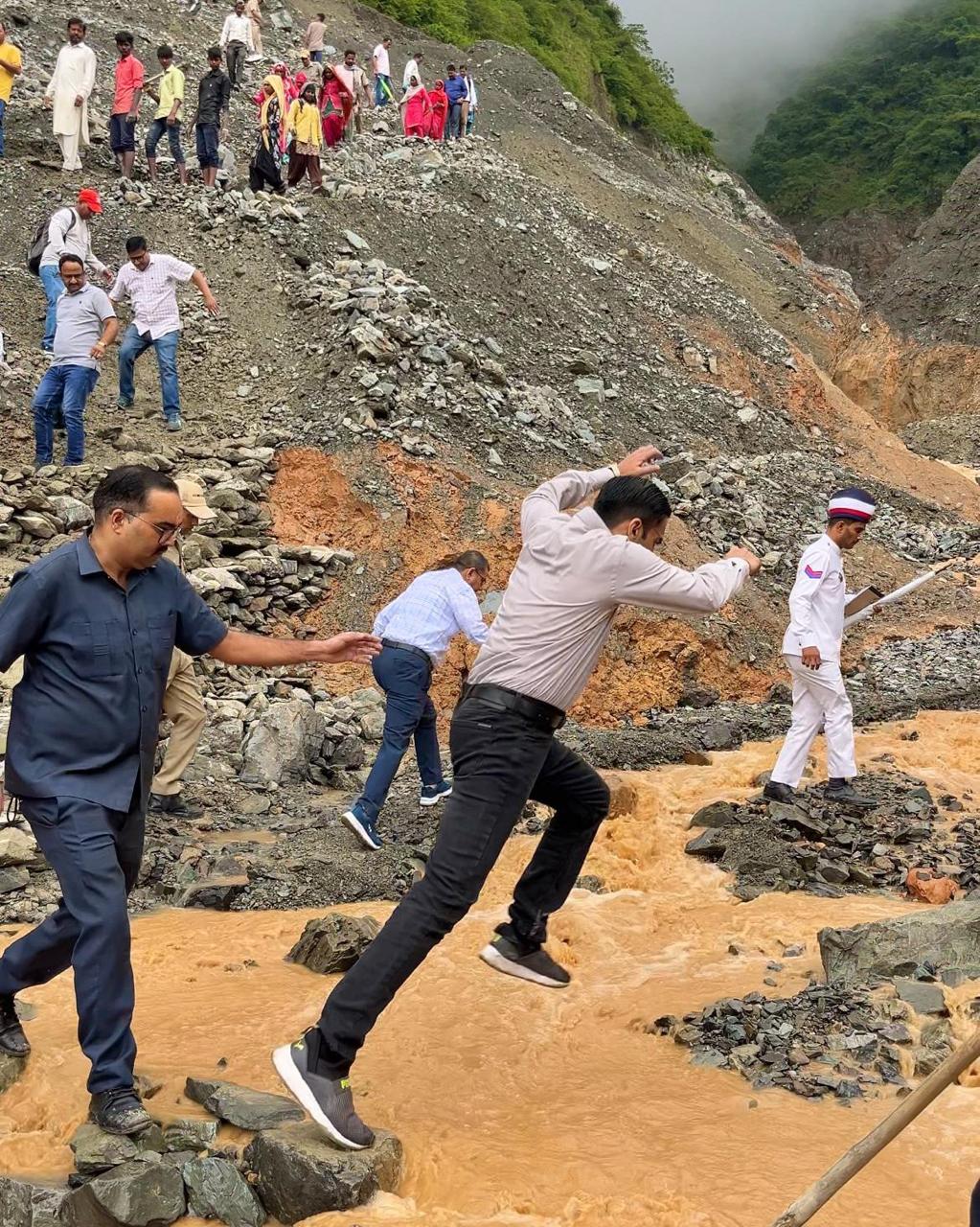 गांव पहुंचने के लिए रास्ता पार करते डीएम। गांव पहुंचने के लिए रास्ता पार करते डीएम।