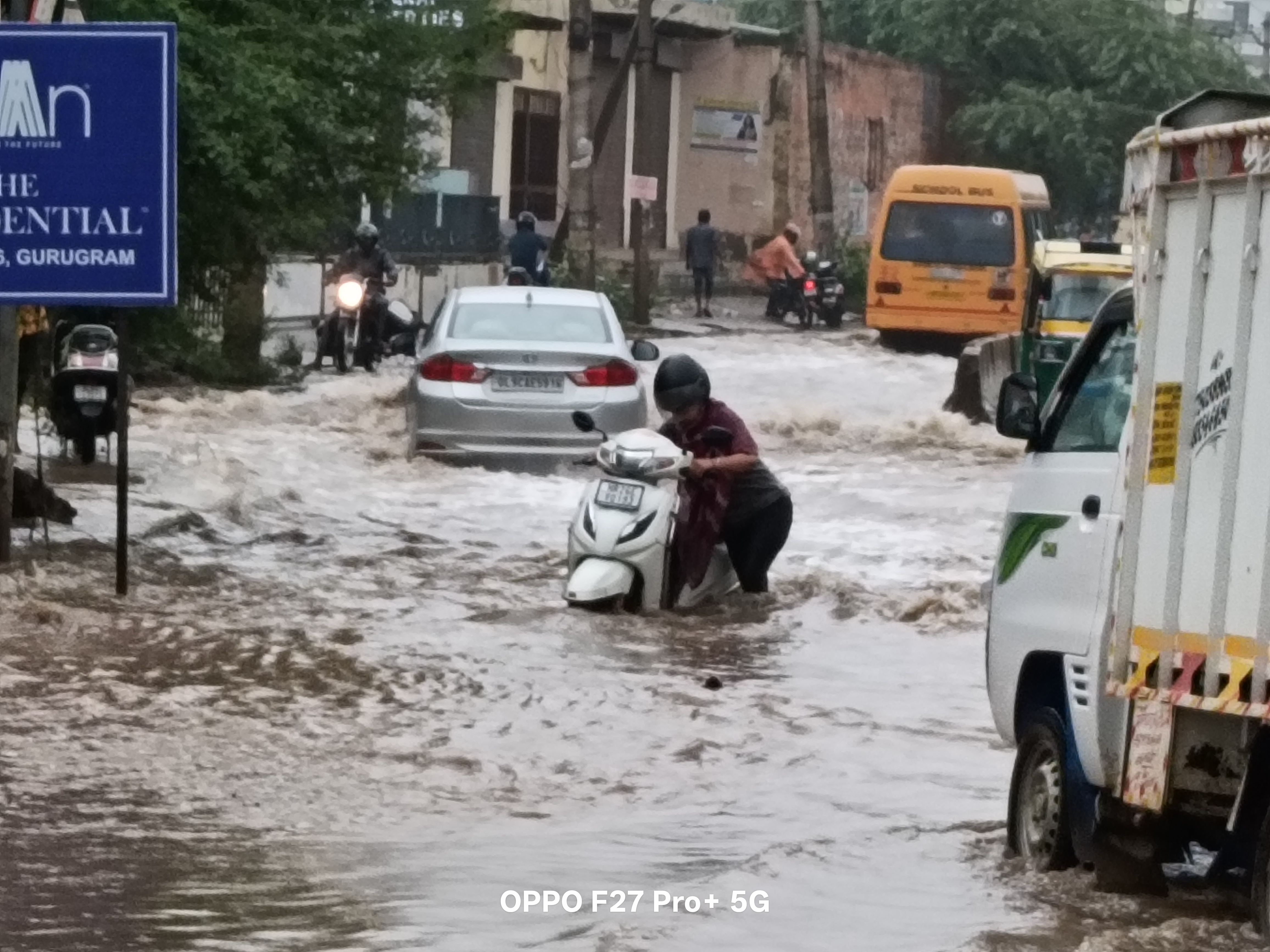 बरसात के भरे पानी में स्कूटी बंद होने से परेशान युवती। बरसात के भरे पानी में स्कूटी बंद होने से परेशान युवती।