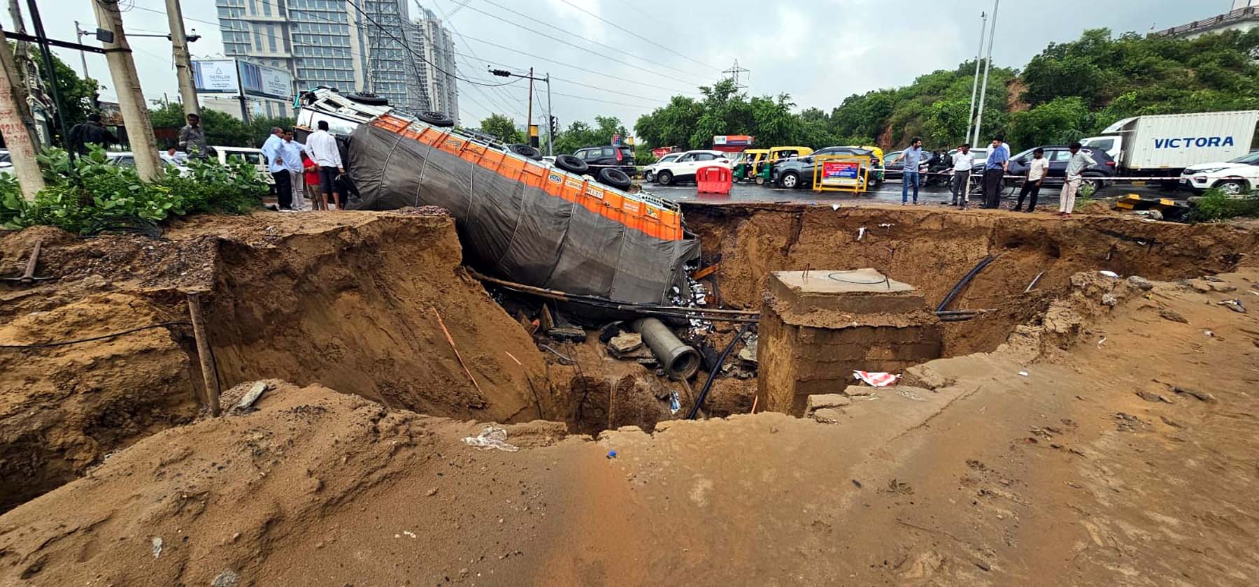 गुरुग्राम में धंसे एसपीआर रोड में बने गहरे गड्ढे में पलटा ट्रक। गुरुग्राम में धंसे एसपीआर रोड में बने गहरे गड्ढे में पलटा ट्रक।