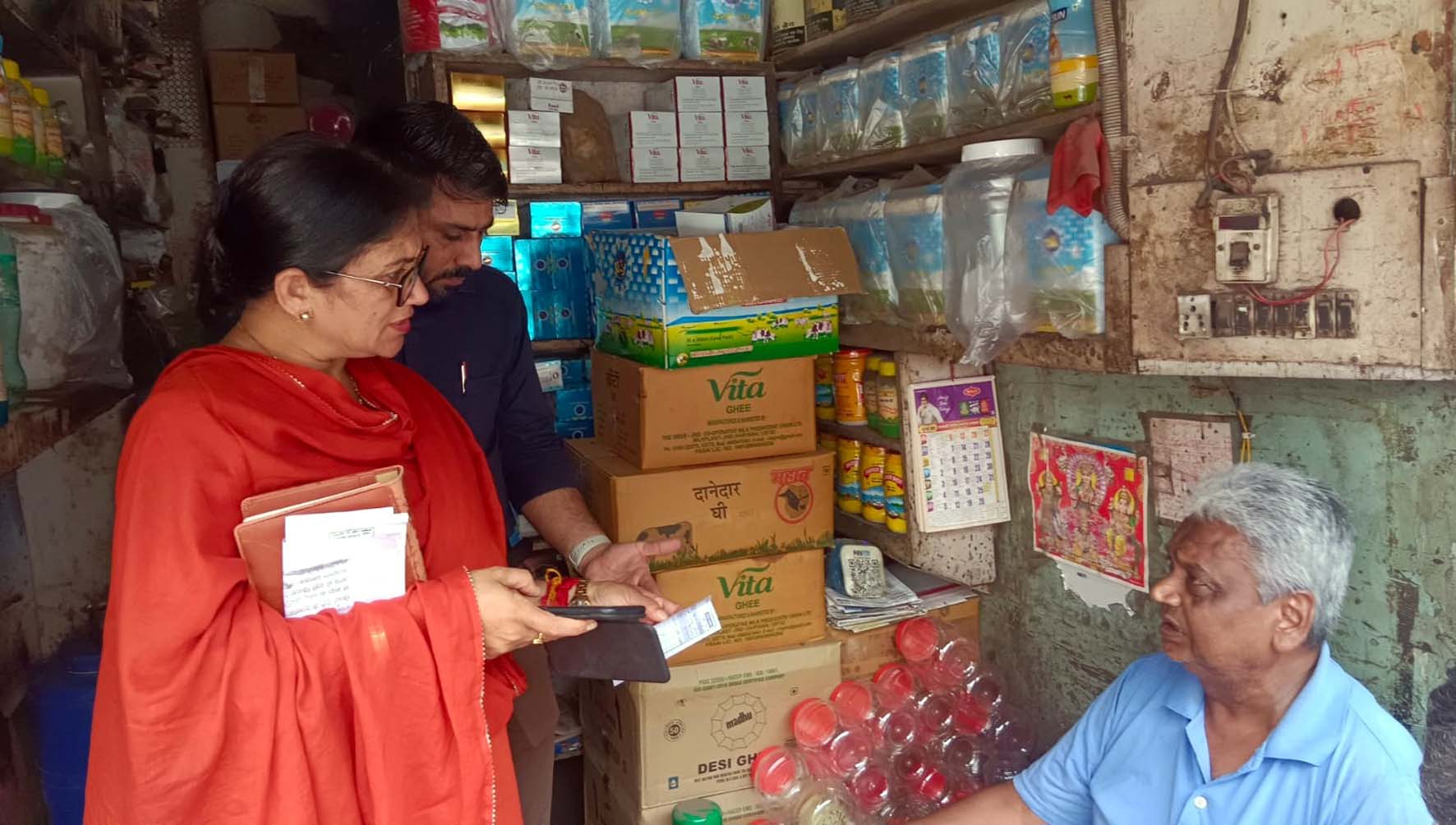 दुकानदार से पूछताछ करके सीएम फ्लाइंग टीम के अधिकारी।