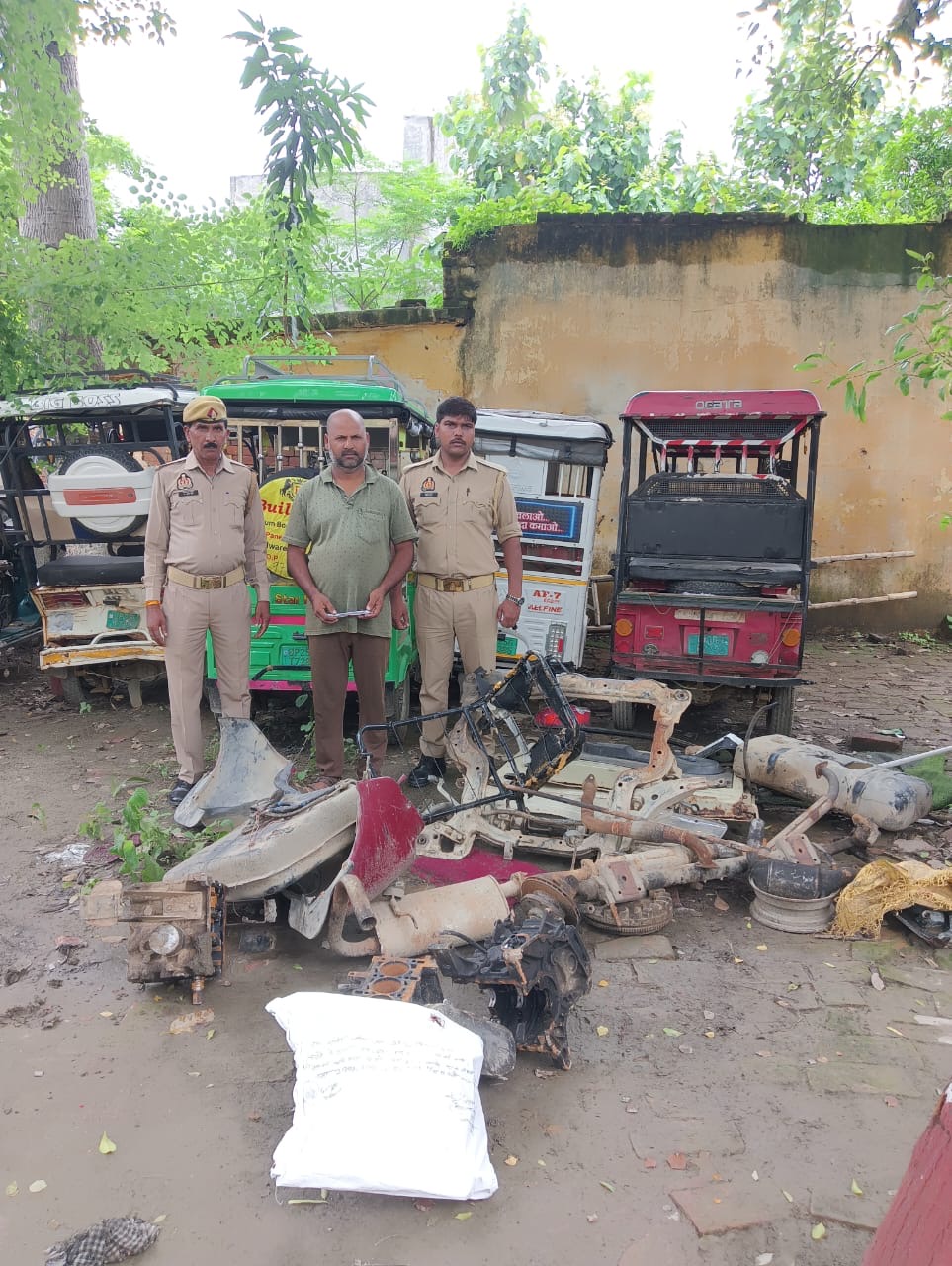 बहेड़ी में कबाड़ी की दुकान पर छापेमारी के दौरान बरामद चोरी के वाहन पुर्जे व औजारों के साथ पुलिस टीम।