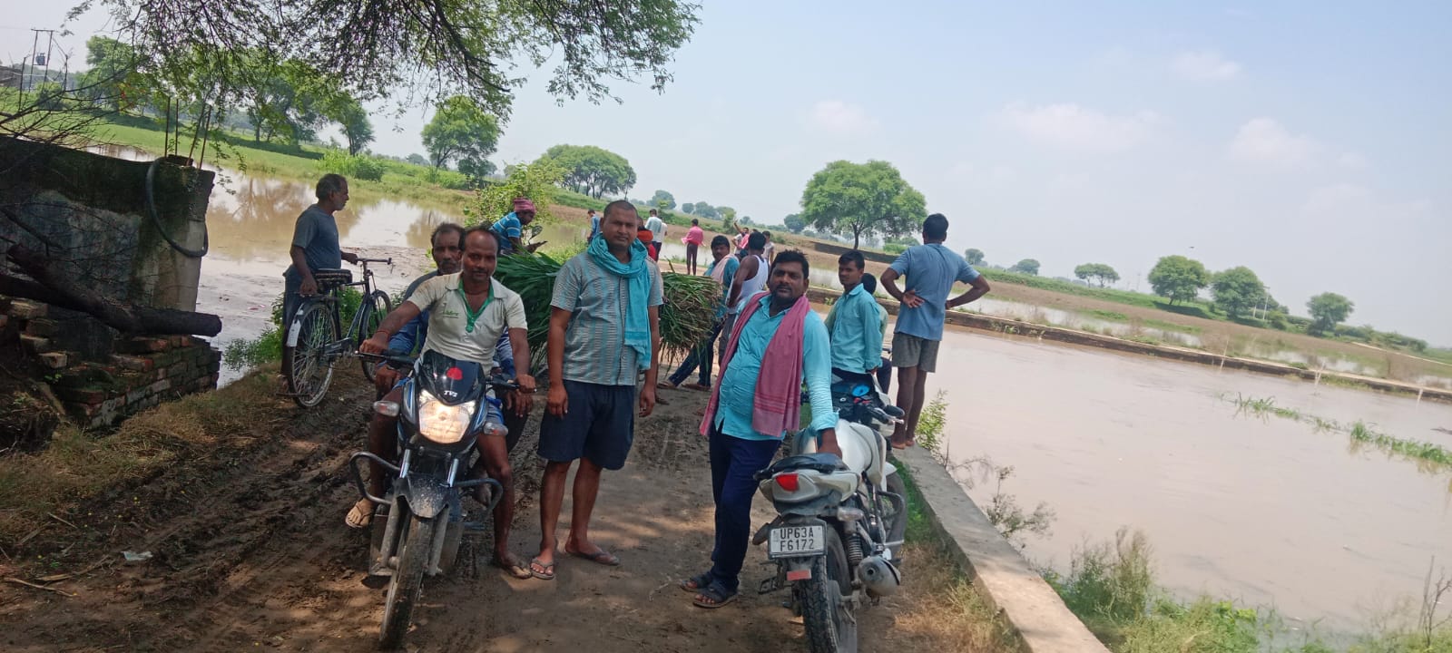 चुनार तहसील क्षेत्र के मझरा गांव में बाढ़ से डूब रहे फसलों को देखते ग्रामीण।