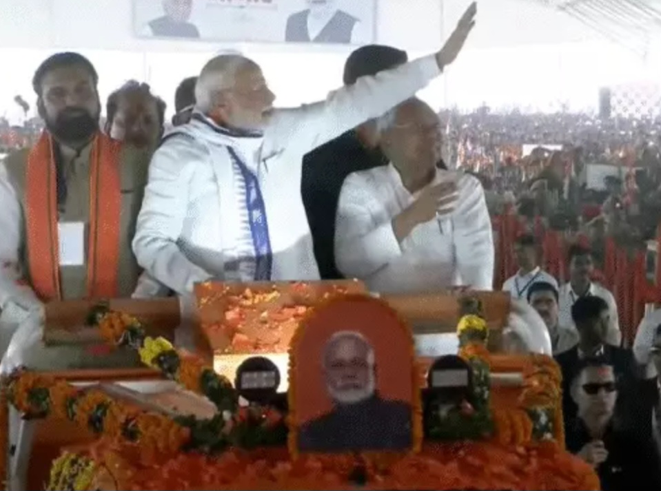 खुली गाड़ी से लोगो का अभिवादन करते पीएम मोदी