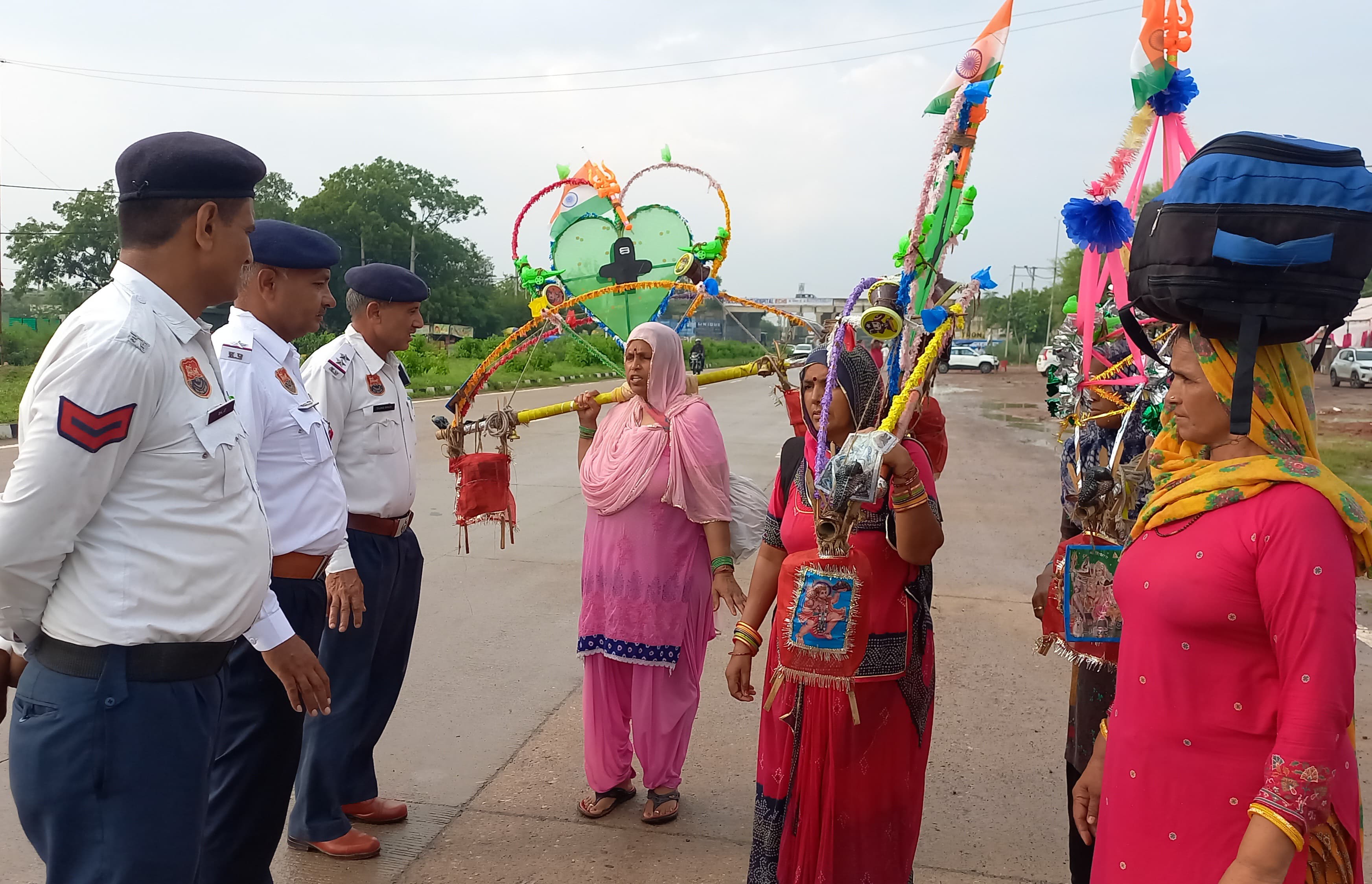 हरिद्वार से कावड़ में गंगाजल लेकर आए ए शिवभक्त महिलाओं से उनका हाल-चाल जानते बहादुरगढ़ में पुलिसकर्मी।