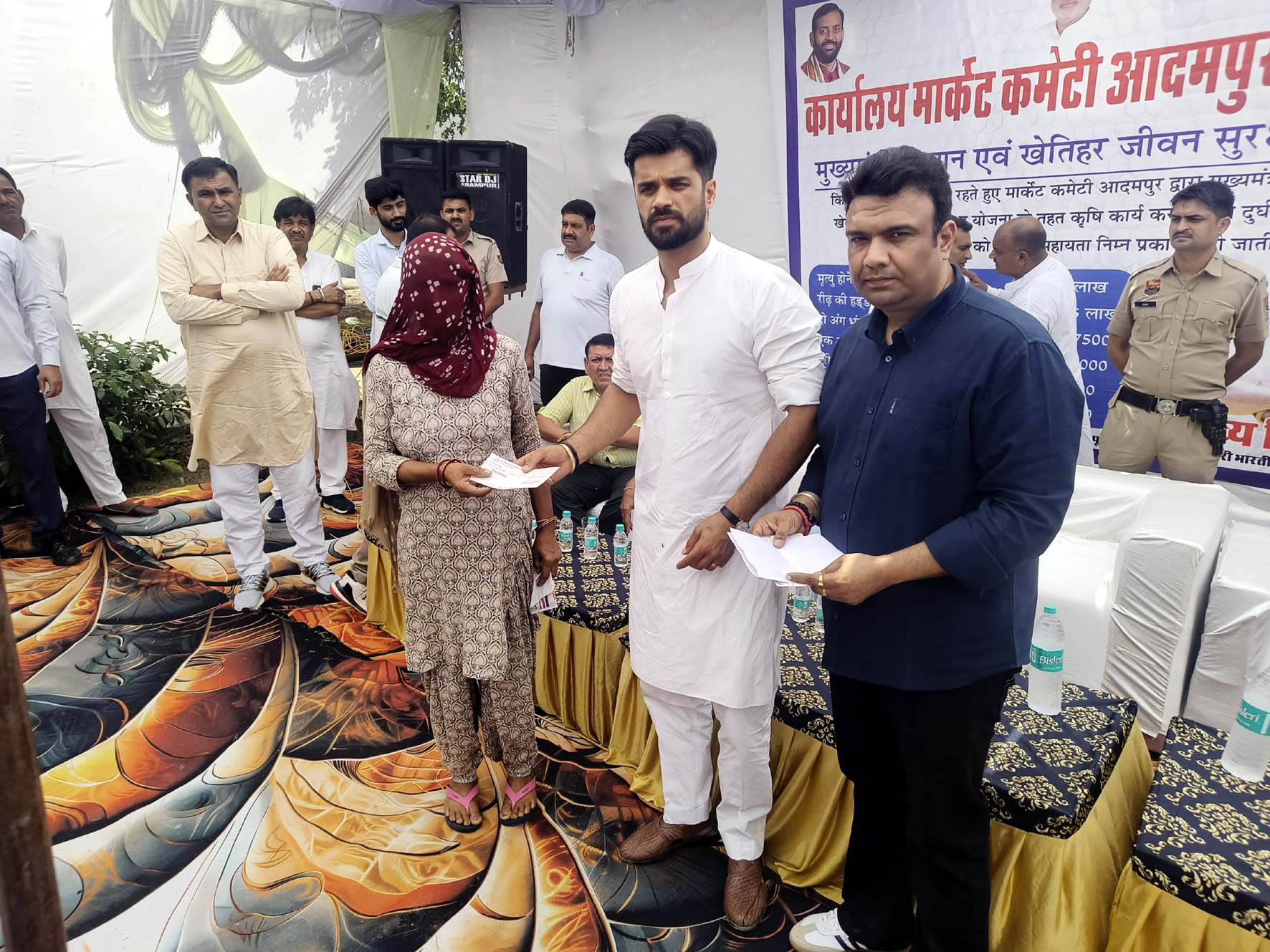 सहायता राशि के चैक वितरित करते हुए भव्य बिश्नोई। सहायता राशि के चैक वितरित करते हुए भव्य बिश्नोई।